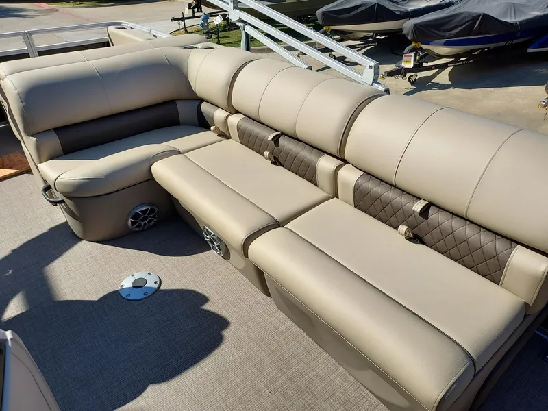 Slide: The Image of 2025 Sun Tracker Sportfish 24 XP3 boat interior with beige seating and speaker system. - 4