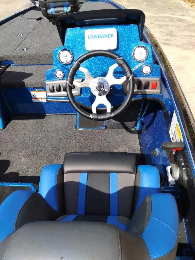 Slide: The Image of 2025 Nitro Z19 boat cockpit with steering wheel and Lowrance electronics. - 2