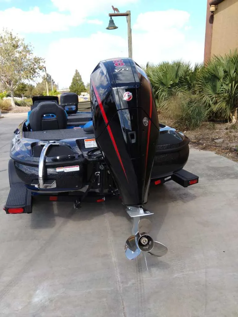 Slide: The Image of 2025 Nitro Z19 boat with powerful outboard motor, parked on concrete driveway. - 3