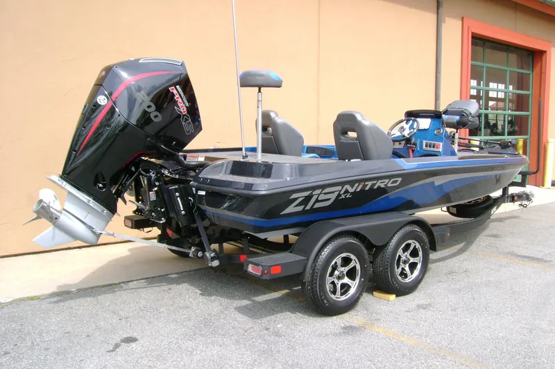 Slide: The Image of 2025 Nitro Z19 boat with powerful outboard motor on a trailer, parked outdoors. - 7