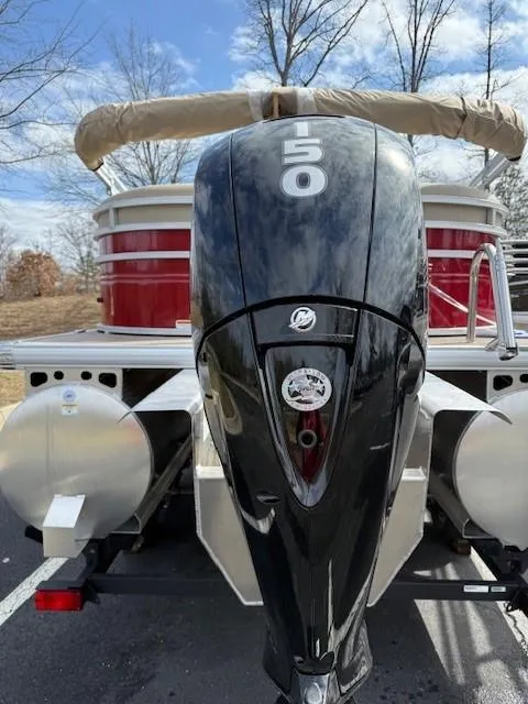 Slide: The Image of 2025 Sun Tracker Party Barge 22 XP3 with powerful 150 HP engine, parked outdoors. - 2