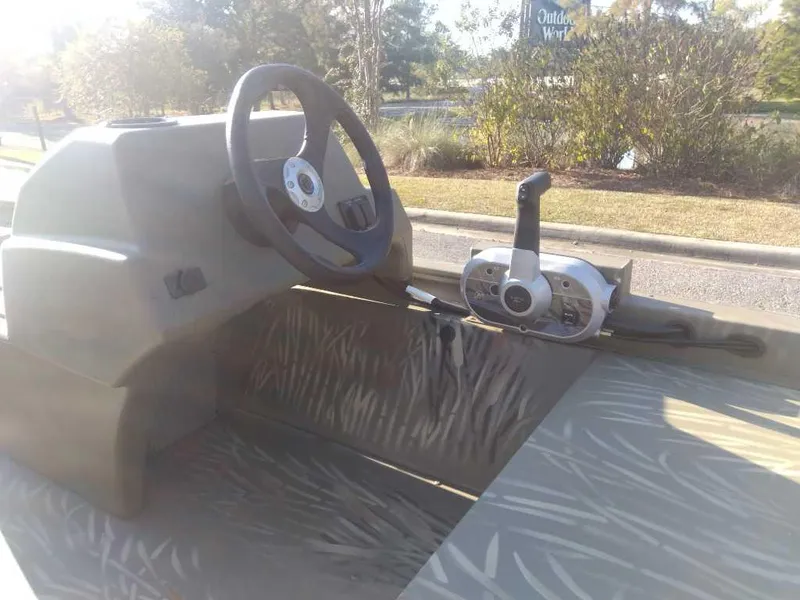 Slide: The Image of 2025 Tracker Grizzly 1648 SC boat interior with steering wheel and control panel. - 11