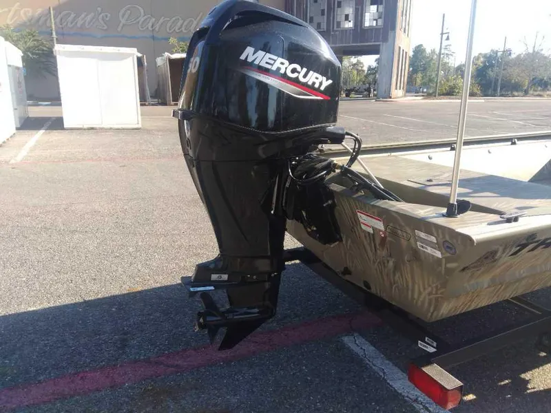 Slide: The Image of 2025 Tracker Grizzly 1648 SC boat with Mercury outboard motor in parking lot. - 3