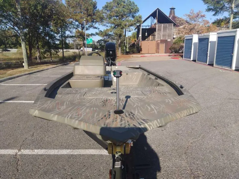 Slide: The Image of 2025 Tracker Grizzly 1648 SC boat in parking lot, camo design, sunny day. - 7