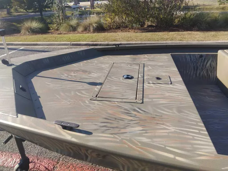 Slide: The Image of 2025 Tracker Grizzly 1648 SC boat with camo pattern deck in outdoor setting. - 8