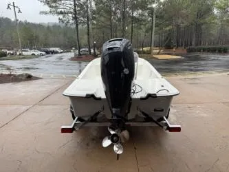 Slide: The Image of 2025 Mako Pro Skiff 17 CC boat, rear view with outboard motor, parked outdoors. - 49