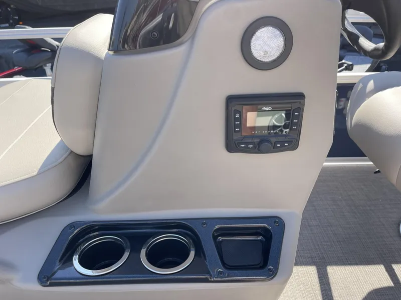 Slide: The Image of 2025 Sun Tracker Bass Buggy 16 XL Select interior with cup holders and audio controls. - 12