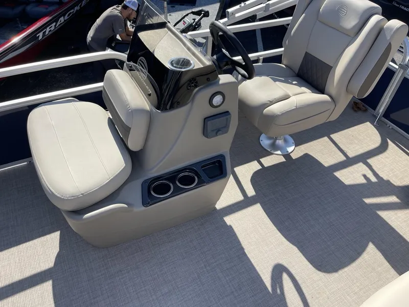 Slide: The Image of 2025 Sun Tracker Bass Buggy 16 XL Select boat interior with beige seating and steering console. - 9
