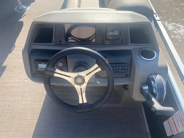 Slide: The Image of 2025 Sun Tracker SportFish 20 DLX boat dashboard with steering wheel and controls. - 2