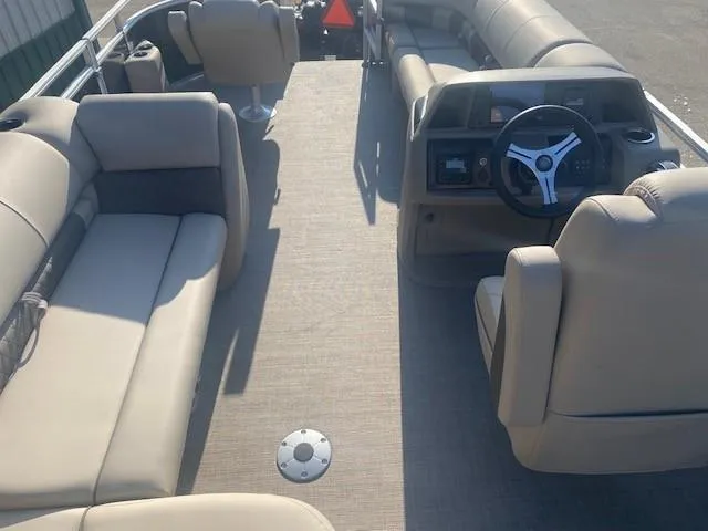 Slide: The Image of 2025 Sun Tracker SportFish 20 DLX pontoon boat interior with beige seating and steering console. - 4