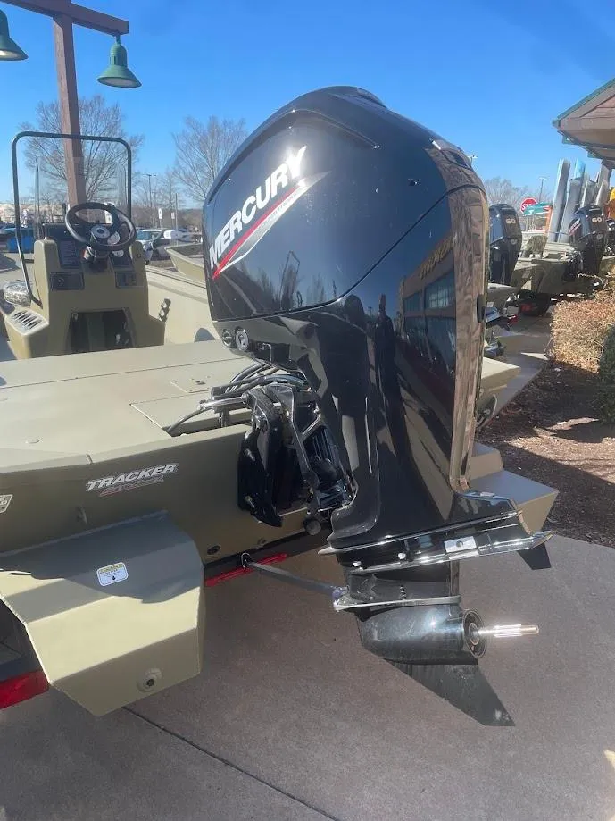 Slide: The Image of 2025 Tracker Grizzly 1860 CC boat with Mercury outboard motor, parked outdoors. - 3