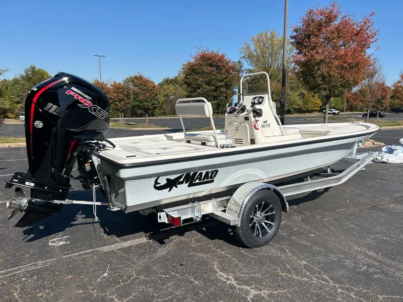 Slide: The Image of 2025 Mako 18 LTS boat on trailer, parked outdoors, with autumn trees in background. - 2