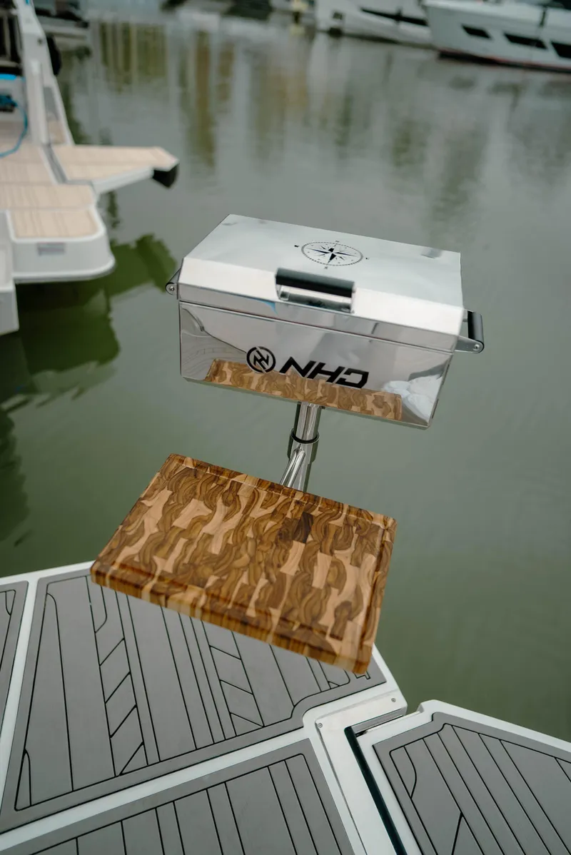 Slide: The Image of NHD 315 Open Deck 2025 boat grill with wooden platform on a dock. - 15
