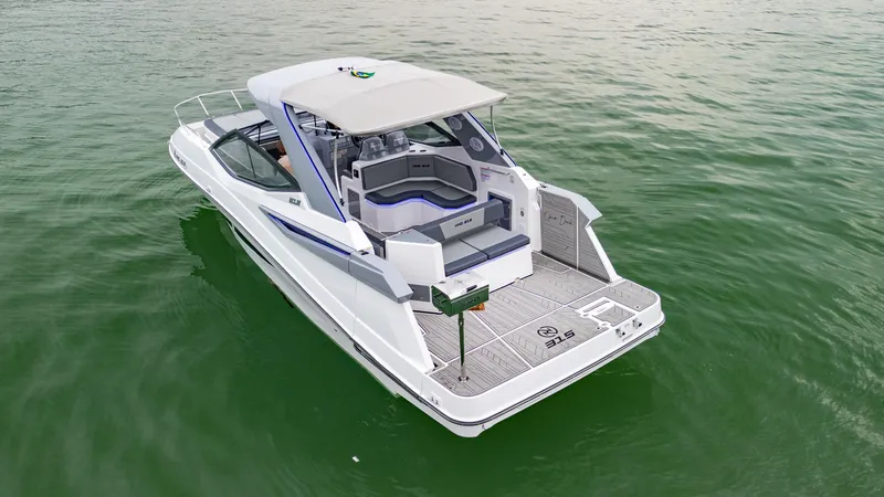 Slide: The Image of 2025 NHD 315 Open Deck boat on calm water, rear view. - 5