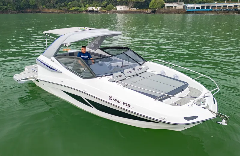 Slide: The Image of 2025 NHD 315 Open Deck boat cruising on a serene lake. - 7