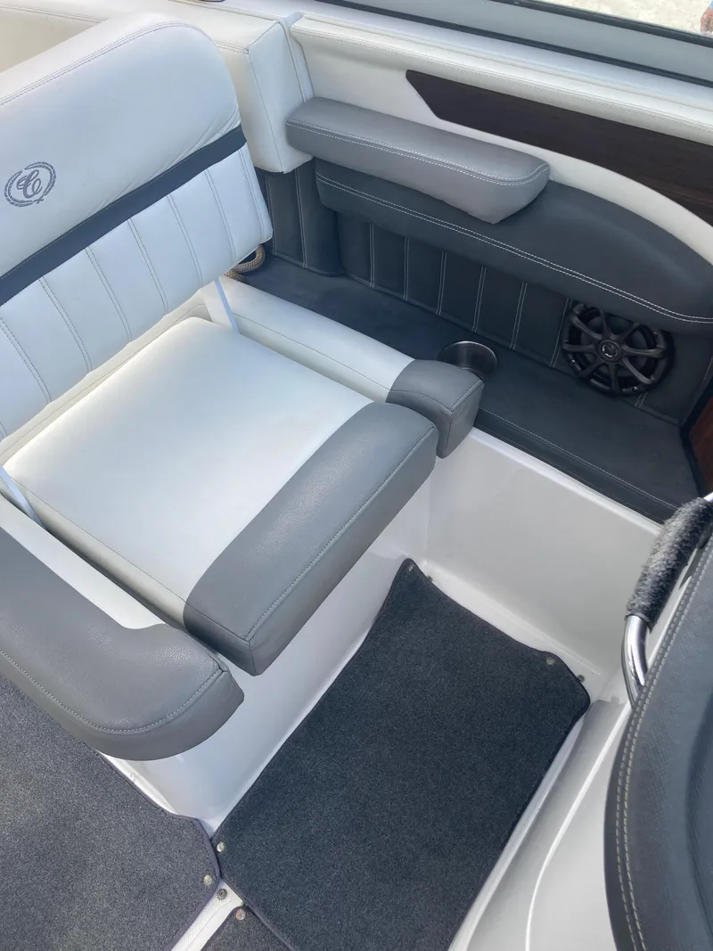 Slide: The Image of 2013 Cobalt 24SD boat interior with gray and white seating and speaker. - 17