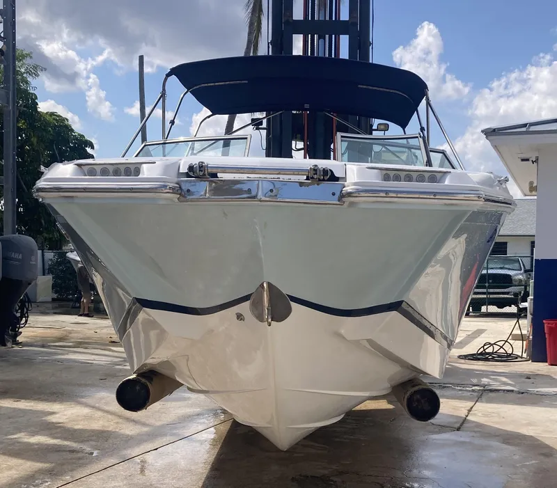 Slide: The Image of 2013 Cobalt 24SD boat with blue canopy, docked under a sunny sky. - 2