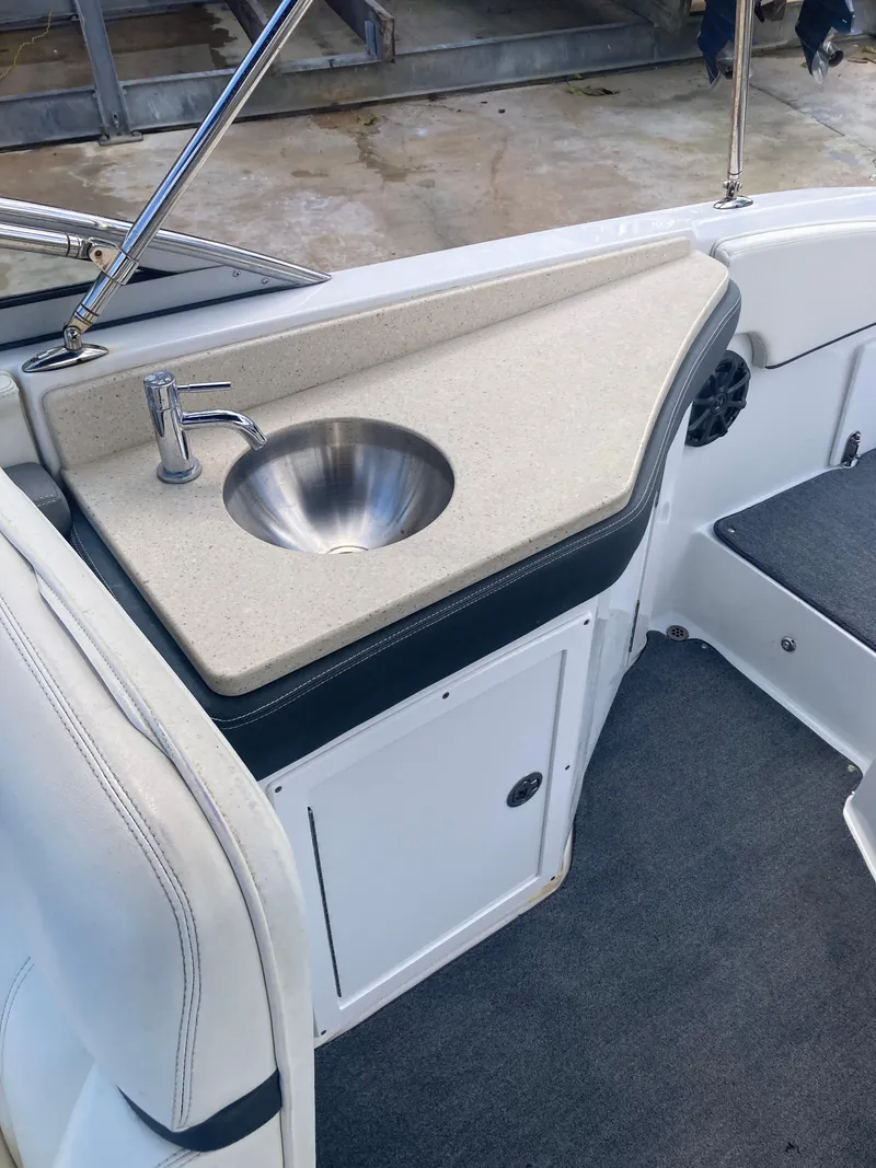 Slide: The Image of 2013 Cobalt 24SD boat interior with sink and storage compartment. - 22