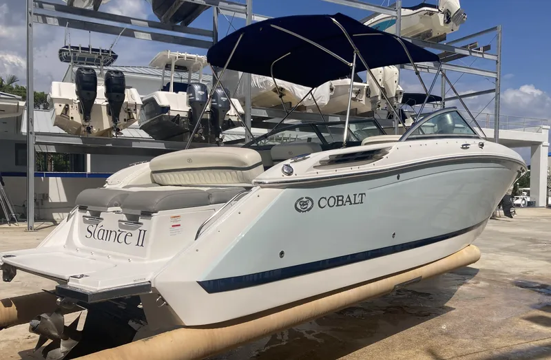 Slide: The Image of 2013 Cobalt 24SD boat with blue canopy in a marina setting. - 4