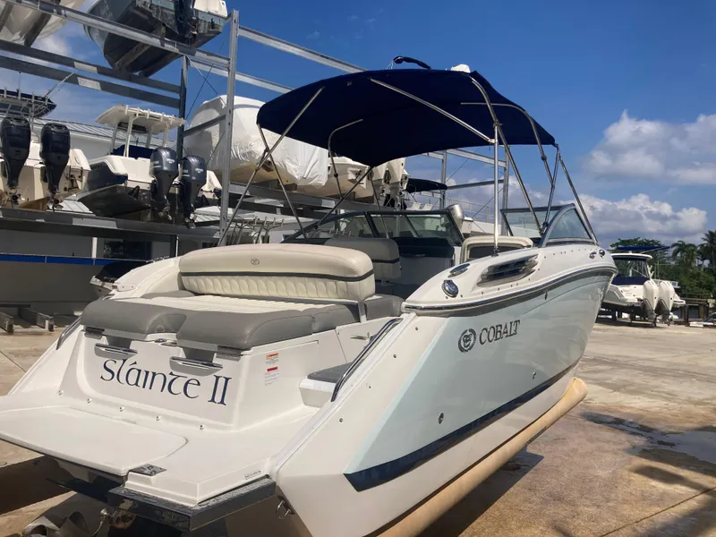 Slide: The Image of 2013 Cobalt 24SD boat with blue canopy, docked under clear skies. - 6