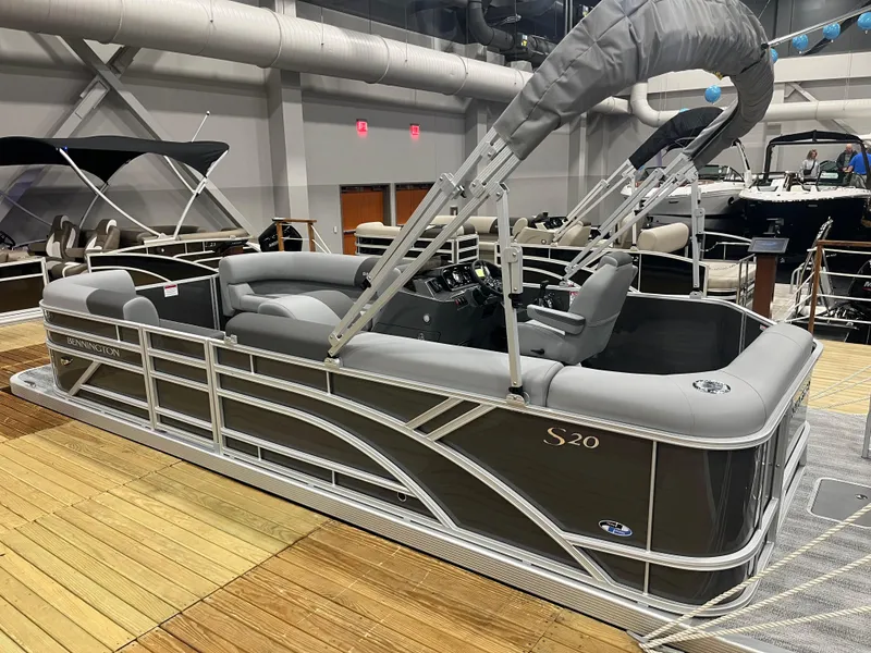 Slide: The Image of 2025 Bennington S Line pontoon boat displayed indoors, featuring sleek design and modern seating. - 0