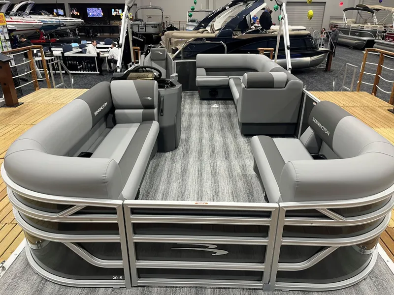 Slide: The Image of 2025 Bennington S Line pontoon boat with spacious seating and modern design at a boat show. - 1