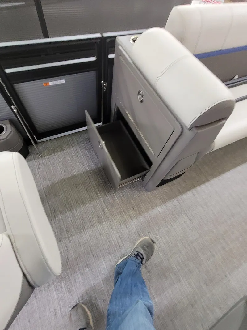 Slide: The Image of 2025 Quest 22 LE interior with open storage compartment and gray seating. - 15