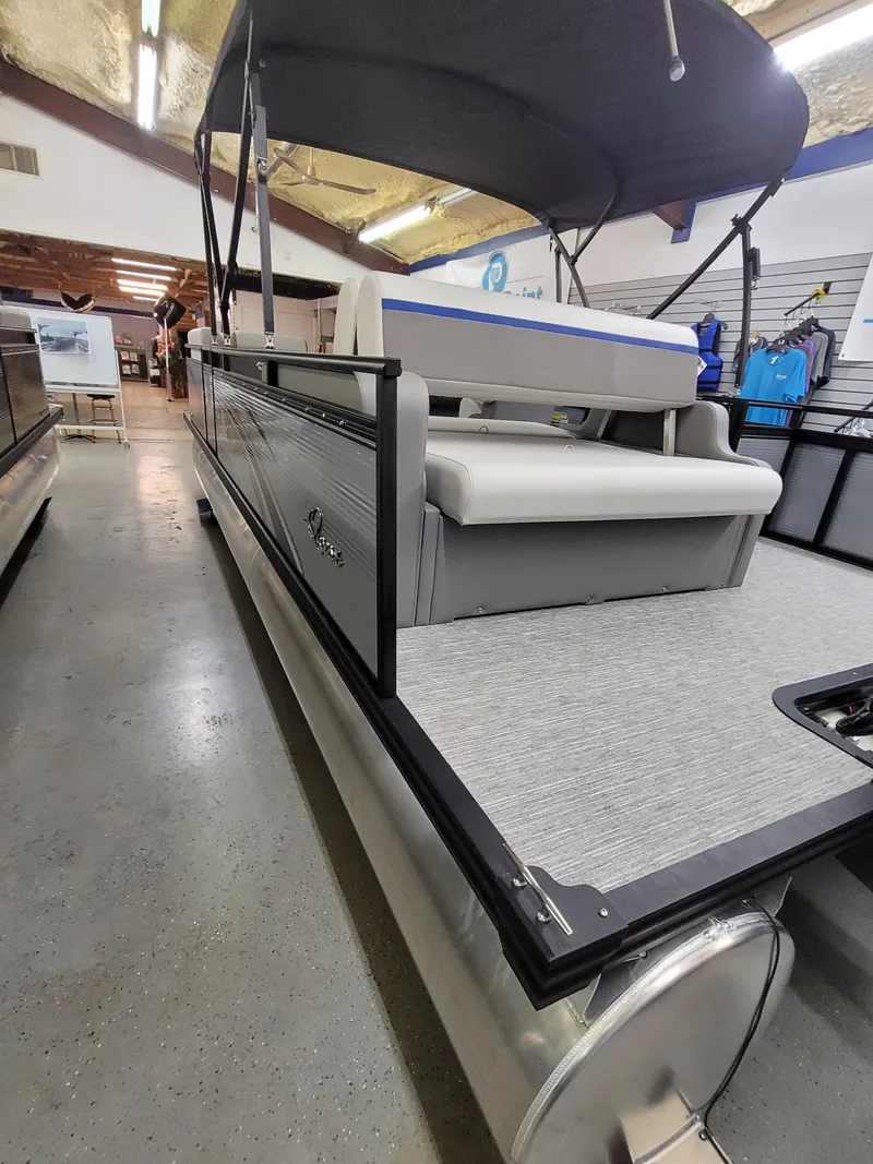 Slide: The Image of 2025 Quest 22 LE pontoon boat in showroom, featuring sleek design and comfortable seating. - 3