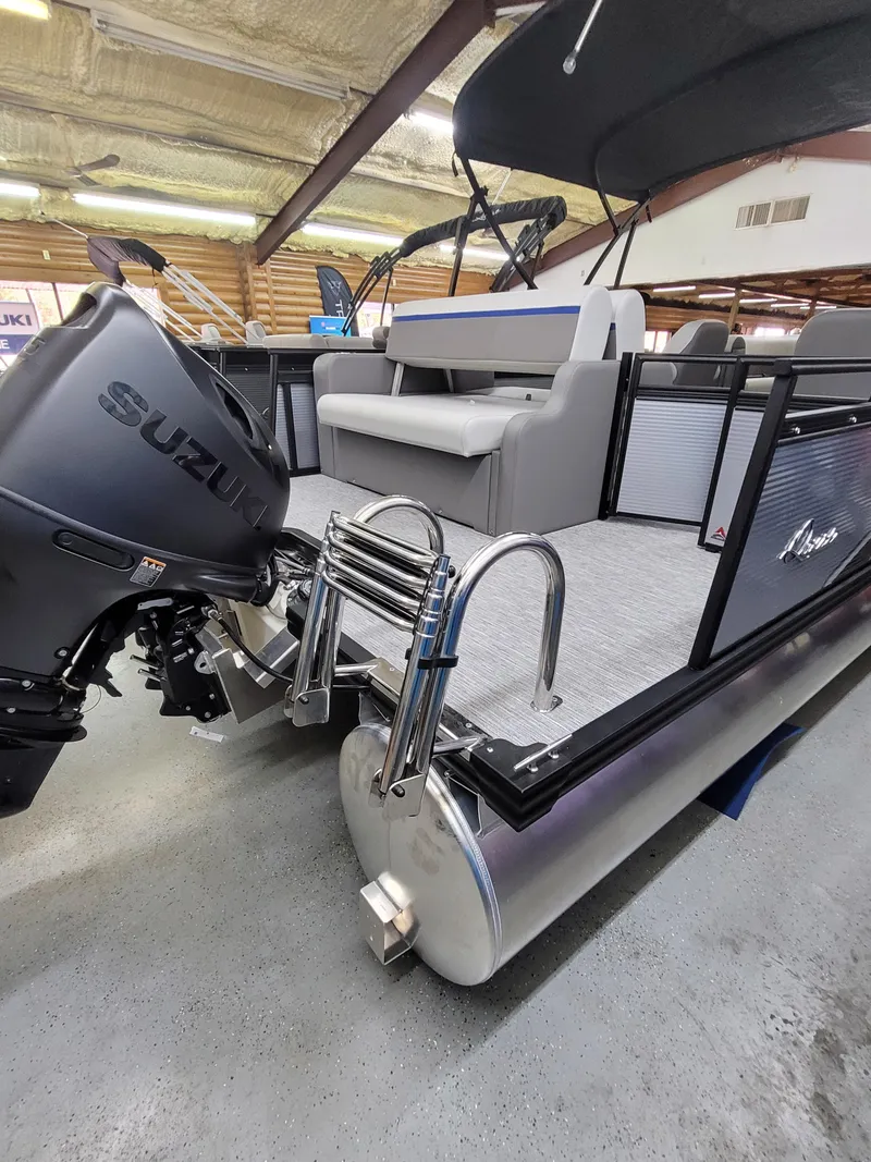 Slide: The Image of 2025 Quest 22 LE pontoon boat with Suzuki motor, docked indoors. - 5