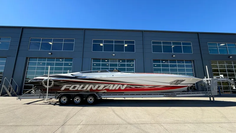 Slide: The Image of 2008 Fountain 47 Lightning boat on trailer, parked outside industrial building. - 0