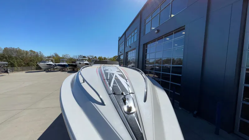 Slide: The Image of 2008 Fountain 47 Lightning boat parked outside a modern building under clear blue sky. - 12
