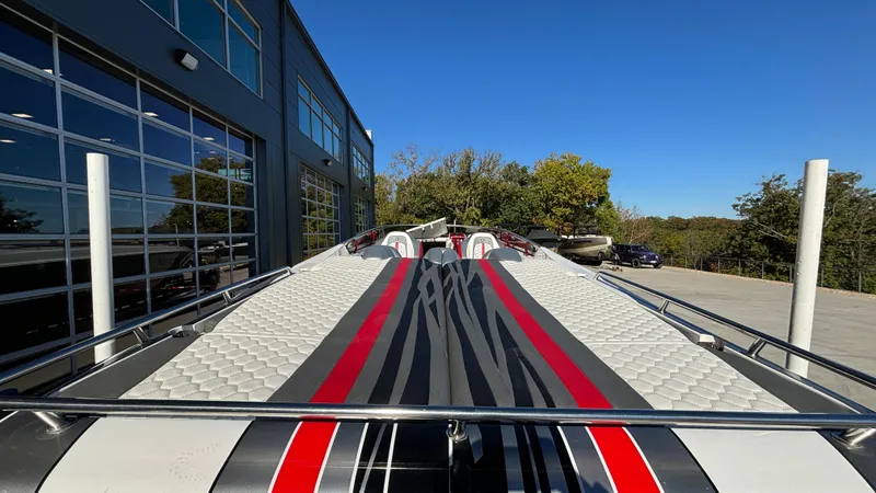 Slide: The Image of 2008 Fountain 47 Lightning boat with sleek red and black design, parked near a building. - 14