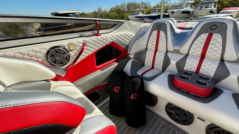 Slide: The Image of 2008 Fountain 47 Lightning boat interior with red and gray seating, cup holders, and speakers. - 23