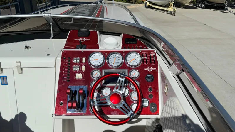 Slide: The Image of 2008 Fountain 47 Lightning boat dashboard with red accents and multiple gauges. - 24