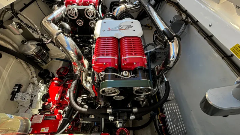 Slide: The Image of Engine compartment of a 2008 Fountain 47 Lightning boat, featuring powerful red and chrome components. - 27