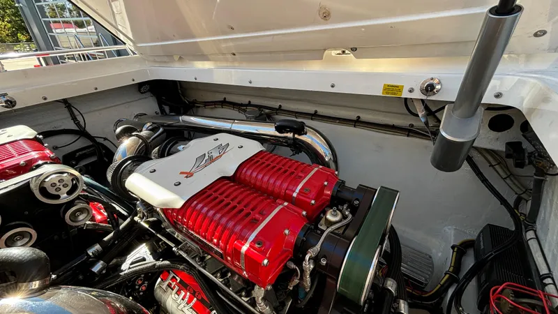 Slide: The Image of Engine compartment of a 2008 Fountain 47 Lightning boat, showcasing powerful red engine components. - 31
