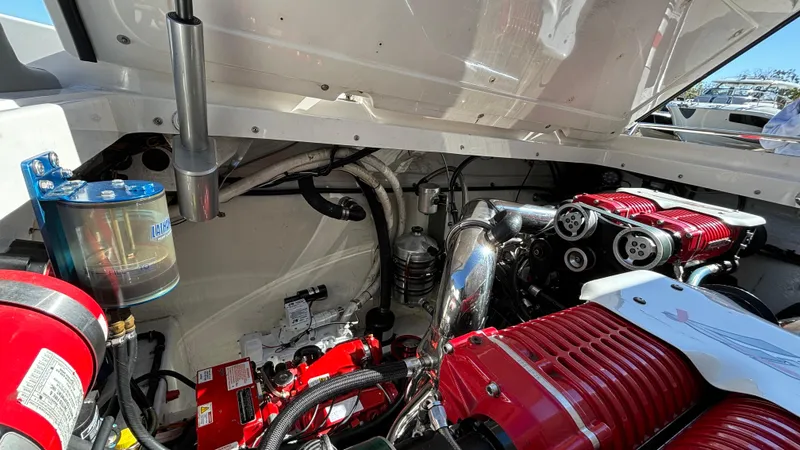 Slide: The Image of Engine compartment of a 2008 Fountain 47 Lightning boat, showcasing red engine components. - 32