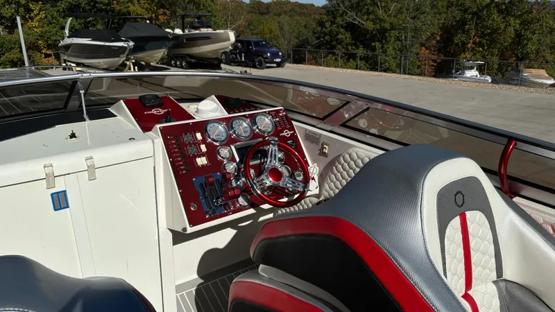 Slide: The Image of 2008 Fountain 47 Lightning boat cockpit with red and white interior, steering wheel, and control panel. - 35