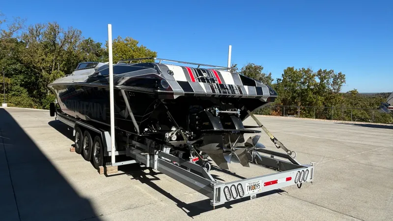 Slide: The Image of 2008 Fountain 47 Lightning boat on trailer, parked outdoors, showcasing sleek design and powerful engines. - 6