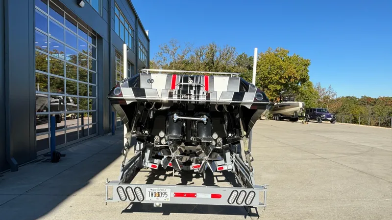 Slide: The Image of 2008 Fountain 47 Lightning boat on trailer, parked outside a garage on a sunny day. - 7