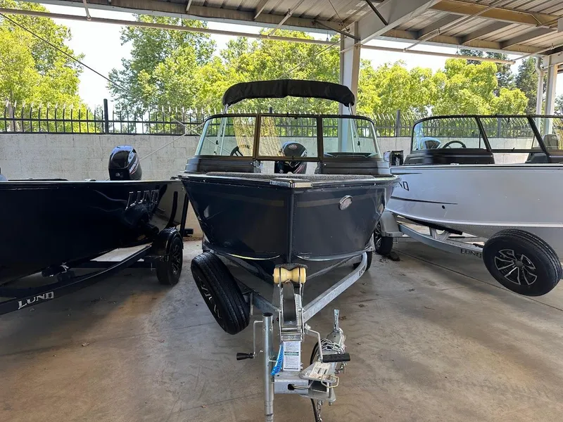 Slide: The Image of 2025 Lund 1775 Adventure Sport boat in showroom, surrounded by other boats. - 1