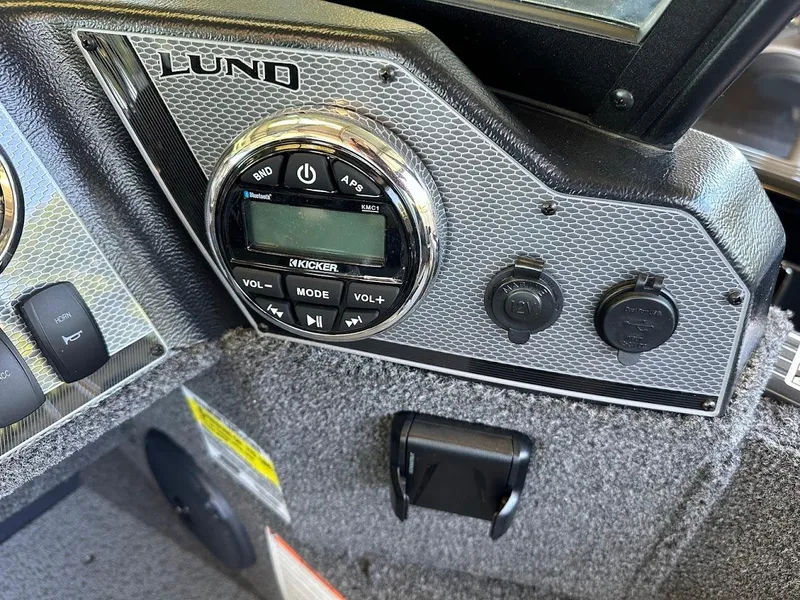 Slide: The Image of Dashboard of 2025 Lund 1775 Adventure Sport boat with audio controls and power outlets. - 10