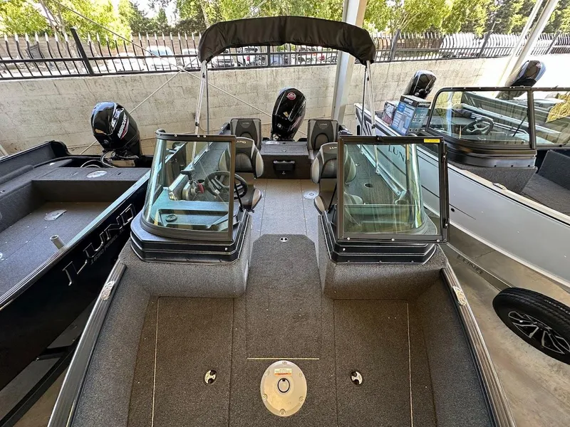 Slide: The Image of 2025 Lund 1775 Adventure Sport boat with dual consoles and outboard motor in showroom. - 15