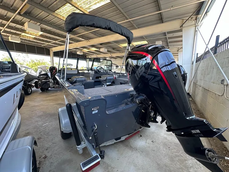 Slide: The Image of 2025 Lund 1775 Adventure Sport boat with powerful outboard motor in a covered storage area. - 3