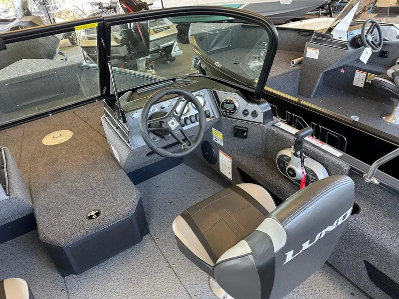 Slide: The Image of 2025 Lund 1775 Adventure Sport boat interior with steering wheel and seating. - 7