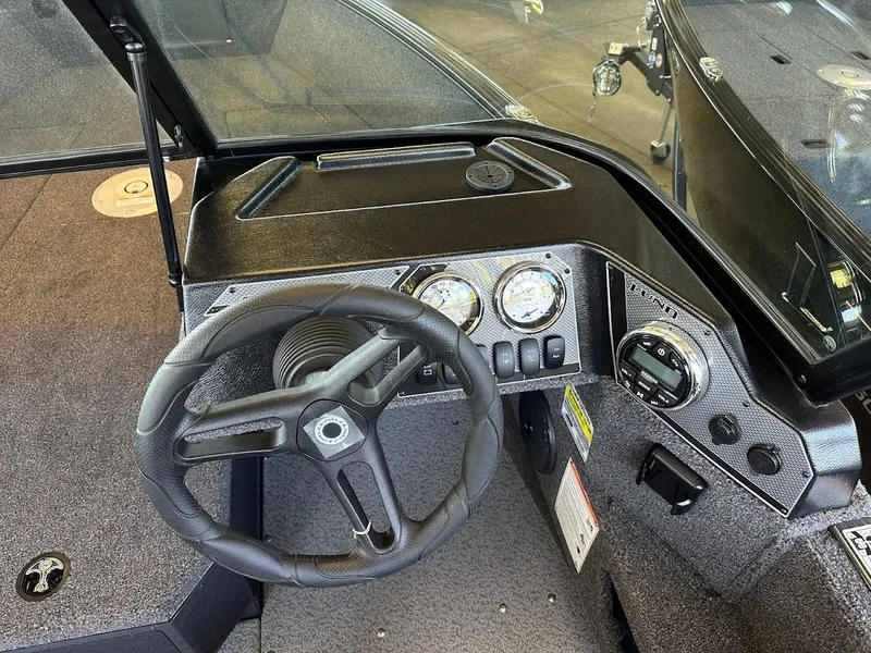 Slide: The Image of 2025 Lund 1775 Adventure Sport boat dashboard with steering wheel and gauges. - 8