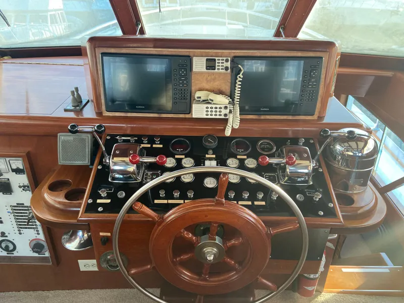 Slide: The Image of 1971 Matthews Custom Pilothouse Motor Yacht helm with wooden wheel and navigation instruments. - 18