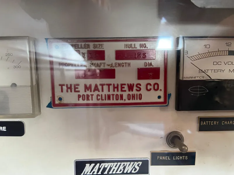 Slide: The Image of 1971 Matthews Custom Pilothouse Motor Yacht control panel with company plaque and gauges. - 20