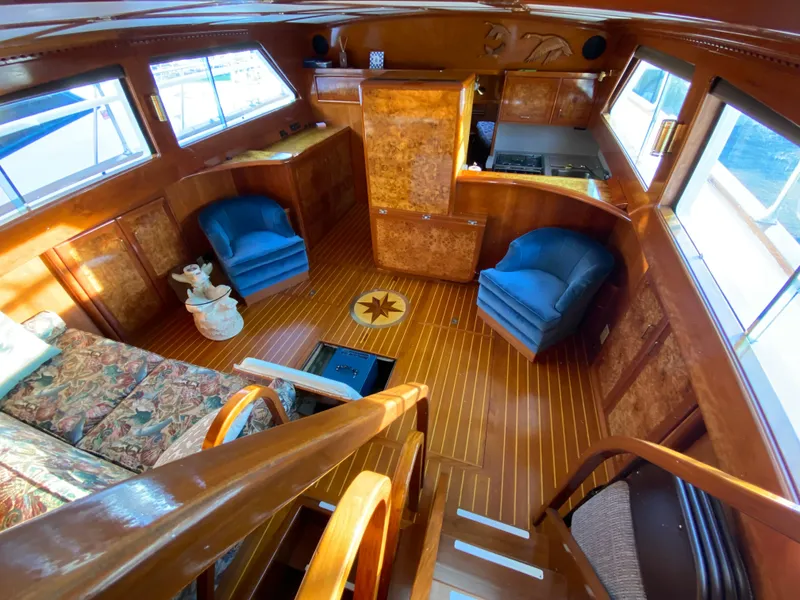 Slide: The Image of 1971 Matthews Custom Pilothouse Motor Yacht interior with wood finish and blue chairs. - 21