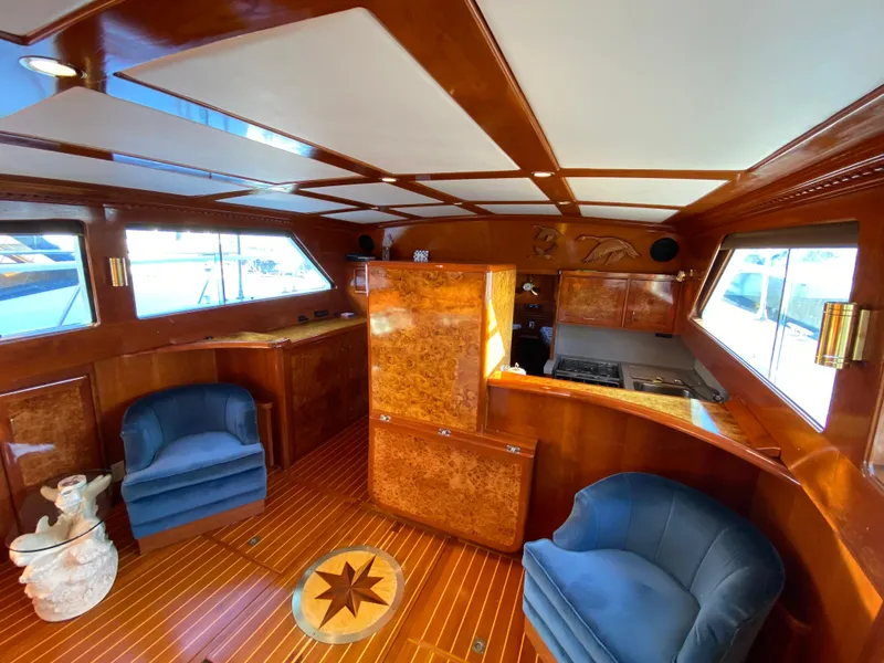Slide: The Image of Luxurious 1971 Matthews Custom Pilothouse Motor Yacht interior with elegant wood finish and plush seating. - 22
